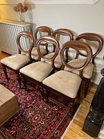 Six chairs arranged in two rows on a rug beside a radiator and coffee table