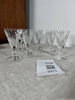 Set of six Waterford Galtee cut sherry or port glasses displayed on cloth against wall.