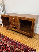 Front view of hardwood sideboard showing two glass pane doors and three drawers