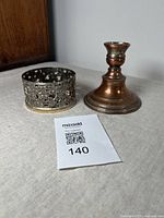 Photo of the silver plated bottle coaster and dwarf candlestick showing their size and condition.