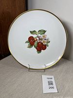 Front view of a round porcelain platter showing detailed cherry and blossom motif with gold rim.