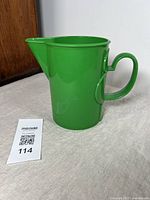 Front view of a green plastic pitcher showing its spout and handle position