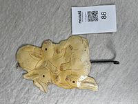 Front view of vintage hand painted bunny hook on fabric surface.