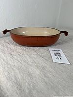 Side view of vintage Le Creuset oval casserole dish showing overall shape and condition with minor wear.