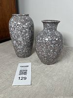 Pair of vintage West German pottery vases with speckled glaze on a light cloth surface against a plain background.