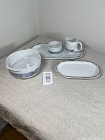 Full view of the Danesco china set showing platter, casserole, sugar bowl, and creamer with geometric pattern band on white ceramic.