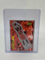 Front of Michael Jordan Upper Deck die-cut sticker #205 in toploader