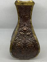 Front view showing embossed floral design and brass trim