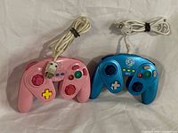 Pink and blue Nintendo Wii/Wii U Fight Pad controllers with cords