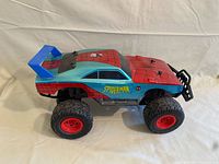 Left side view of Spider-Man RC monster truck showing body graphics and tire wear