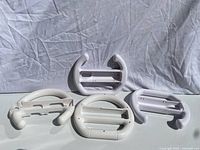 All four white plastic Wii wheel attachments laid out