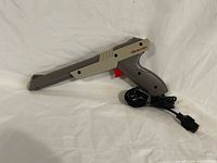 Full view of gray Nintendo Zapper with cable and NES plug
