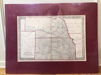 Full view of framed antique map of Kansas and Nebraska, showing state boundaries, county and township divisions, with a decorative border around the entire map.