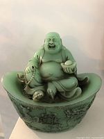 Front view of seated Laughing Buddha on ingot base