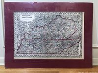 Full view of the antique map mounted on a maroon backing, showing the entire area of Kentucky and Tennessee with visible original hand coloring on the borders and state outlines.