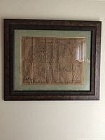 Framed antique map hanging on wall showing entire map of Yorkshire by John Speed, aged paper with visible creases and discoloration.