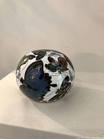 Close-up of the cloisonne ball showing large blue and multi-color butterflies with gold outlining against a white background.