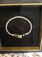 Top view of vintage sterling silver bracelet, showing twisted silver band and square clasp bauble.