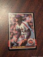 Front of the 1985 Donruss Ron Darling rookie card showing the player in Mets uniform pitching with logos and name visible.