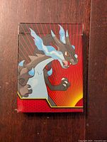 Front of the sealed deck box featuring Mega Charizard X artwork on a red background.