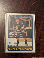 Front view of Rod Brind'Amour rookie hockey card showing player in St. Louis Blues uniform with blue, white, orange border and nameplate at bottom.