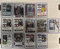 Top-down image of 15 autographed football trading cards arranged in 3 rows of 5 cards each, showing various players, autograph ink colors, holographic details, rookie tickets, and limited edition numbering.