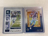 Two CeeDee Lamb rookie football cards in plastic protectors, one from Chronicles series and one with frame design