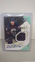 Front view of autographed Alex Plante Edmonton Oilers SPX Upper Deck hockey card in protective case showing player image, jersey patch, and blue ink signature.