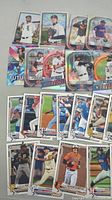 Photo showing a collection of 2021 Topps Bowman baseball rookie cards with players in various poses and uniforms including White Sox, Cardinals, and others.