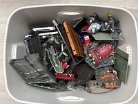Bin filled with various Marvel Legends and Diamond Select bases, accessories, and stands in multiple designs and colors.