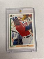 Front of 1990 Upper Deck Michael Jordan MLB rookie card SP1, showing Jordan batting in a red Chicago White Sox uniform, encased in clear plastic holder.