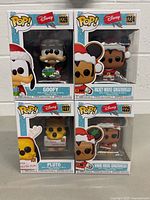 Front view of all four Disney Pop! Funko figures in original packaging: Goofy (#1226), Mickey Mouse Gingerbread (#1224), Pluto (#1227), Minnie Mouse Gingerbread (#1225) showing holiday themed designs and box art.