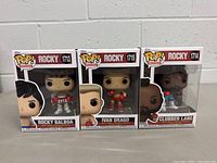 Photo showing all three boxed Funko Pop! figures from the Rocky movie series: Rocky Balboa (#1713), Ivan Drago (#1715), and Clubber Lang (#1714).