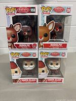 Front view of the four Funko Pop! vinyl figures in original packaging, showing two Rudolph and two Santa Claus figures from the Rudolph The Red-Nosed Reindeer Movie series.
