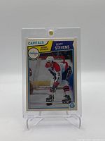 Front image of 1981-82 O-Pee-Chee Scott Stevens rookie card showing player in Washington Capitals uniform on ice.