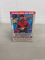 Front view of the sealed box showing the 2024 Goodwin Champions branding with image of a golfer and note about autograph hits, platinum variants, and patches.