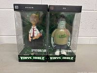 Front view of Shaun and Ed action figures in original Vinyl Idolz packaging showing front of boxes and figures