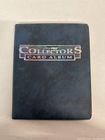 Black Ultra PRO Collectors Card Album binder closed with title on front.