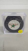 Dallas Stars hockey puck with Brian Bellows signature in clear display case showing front logo and autograph.