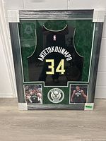 Front view of the custom framed jersey wrapped in protective plastic and corner guards