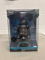 Front view of the sealed packaged Star Wars C2-B5 die cast action figure showing the figure through the clear window, with Star Wars branding and Disney Store logo.