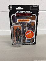 Front view of the Mandalorian action figure packaged on a retro style card