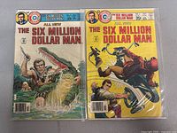 Both comics side by side in protective sleeves, showing the colorful covers including the man fighting the crocodile and the motorcycle attack scene.