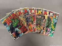 Lot of 8 vintage Incredible Hulk comic books displayed in a fanned arrangement showing various covers including Hulk fighting and action scenes.