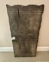 Close-up view of carved wood wall hanging showing geometric patterns