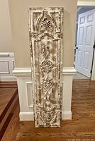 Front view of the large distressed wood decorative panel showing carved details and heavy white paint distressing.