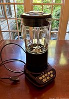 Photo shows cobalt blue Kitchenaid blender with glass jar and control buttons on base, lid on top, power cord visible.