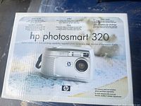 Retail box showing HP Photosmart 320 branding and camera image