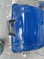 Top view of blue lid with black handle and attached propane connection