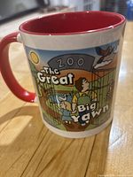 Ceramic mug showing The Great Big Yawn zoo graphic, red interior and handle